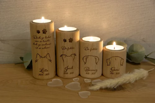 Teelichthalter rund, aus Buchenholz, Größe 6, 8, 10 und 12 cm, personalisiert mit Hundeohren, Namen und Geburts- und Sterbejahr. Jeweils mit einem brennenden Teelicht, dekoriert auf einem Holztisch