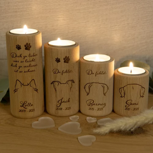 Teelichthalter rund, aus Buchenholz, Größe 6, 8, 10 und 12 cm, personalisiert mit Hundeohren, Namen und Geburts- und Sterbejahr. Jeweils mit einem brennenden Teelicht, dekoriert auf einem Holztisch