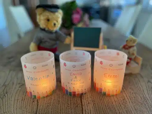 Lichthüllen Einschulung Einschulung aus transparentem Papier, für Mädchen, Jungen und Zwillinge, bedruckt mit Farbstiften, Meine Einschulung, dem Namen und dem Datum der Einschulung. Dekoriert auf einem Holztisch mit entzündeten Teelichtern