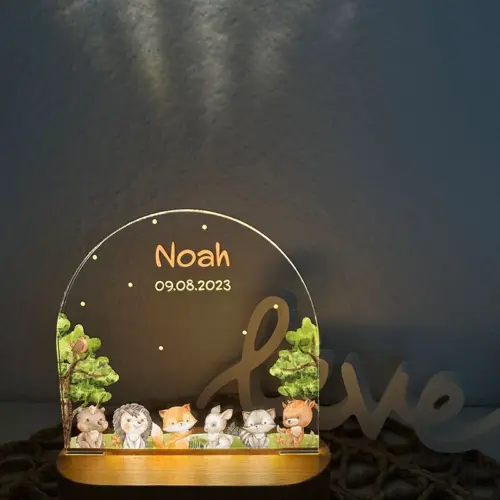 LED Nachtlicht für Kinder, ovaler, massiver Holzsockel mit Touchscreen, Acrylscheibe bedruckt mit einer Szene im Wald. Dargestellt sind Waldtiere in Aquarelloptik.