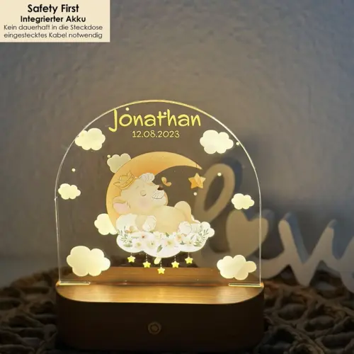 LED Nachtlicht für Kinder, ovaler, massiver Holzsockel mit Touchscreen, Acrylscheibe bedruckt mit auf einem Mond lliegenden Löwenbaby-Motiv in Aquarelloptik.
