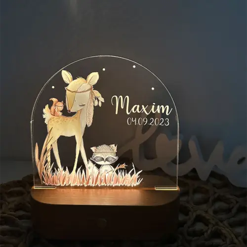 LED Nachtlicht für Kinder, ovaler, massiver Holzsockel mit Touchscreen, Acrylscheibe bedruckt mit einem Reh mit einem Eichhörnchen auf dem Rücken und davor ein Waschbär im Gras, in Aquarelloptik