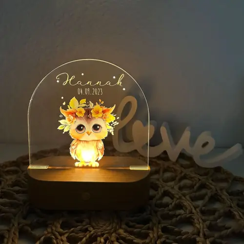 LED Nachtlicht für Kinder, ovaler, massiver Holzsockel mit Touchscreen, Acrylscheibe bedruckt mit Tierbaby-Motiven in Aquarelloptik. Abgebildet ist eine kleine Eule mit Blumengebinde auf dem Kopf