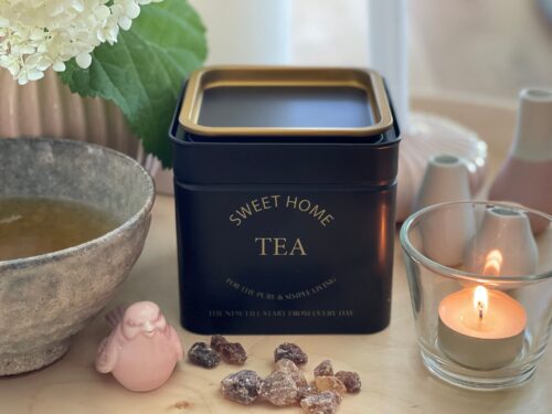 Mattchwarze, quadratische Teedose, mit goldenem Rand am Deckel, personalisiert mit goldenem Aufdruck "SWEET HOME TEA"
