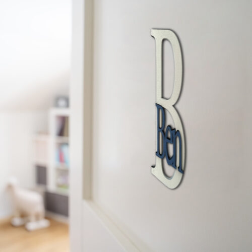 Namensschild für die Zimmertüre aus MDF, zweifarbig lackiert. Das Türschild besteht aus einem 20 cm großen Buchstaben B und dem ausgeschriebenen Namen Ben, fixiert auf dem Großbuchstaben. Befestigt an einer weißen Türe.